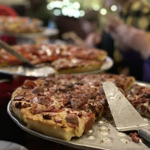 a variety of pizzas on trays