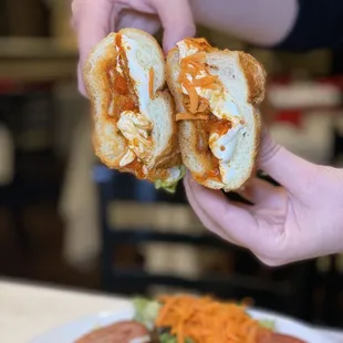 a person holding a half eaten sandwich