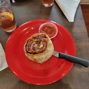 a red plate with a pastry on it