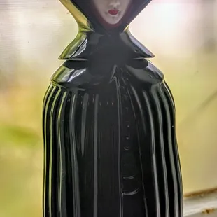 Fascinating liqueur bottle keeping an eye on things in the restroom.