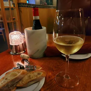 a glass of wine and a plate of bread