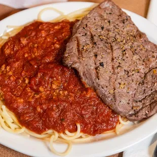 a plate of meat and spaghetti