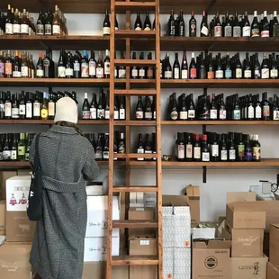 a woman looking at bottles of wine