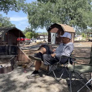 Little area with your fire pit and the two bathrooms and showers in the background and two camp sites