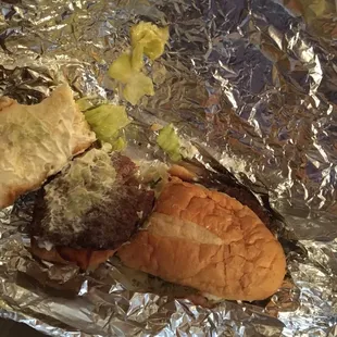 a hamburger and a sandwich wrapped in tin foil