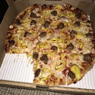 I ate a slice in the car of the sausage, onion, and banana pepper pizza.