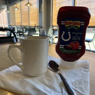 Cup of coffee,spoon,napkin and RED GOLD OFFICIAL KETCHUP of the INDIANAPOLIS COLTS.