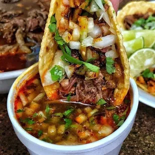 Birria tacos. And some birria juice.in a cup.