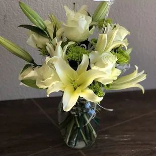 Simplicity sympathy arrangement. Lillies, roses, green button mum, white bows, glass vase