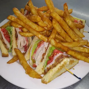 a plate of french fries and a club sandwich