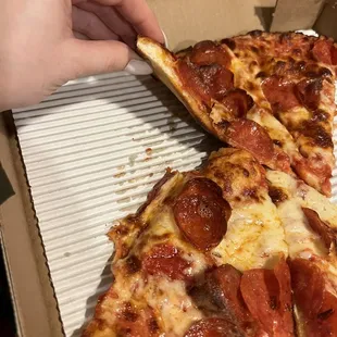 Undercooked but also overcooked pepperoni pizza. Flat burnt crust.