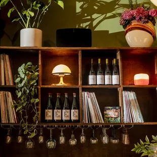 a shelf of wine glasses and wine bottles