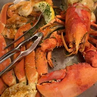 Steamed Whole Maine Lobster stuffed with crab cake and sides of shrimp and fries