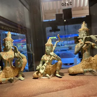 three figurines in a glass case