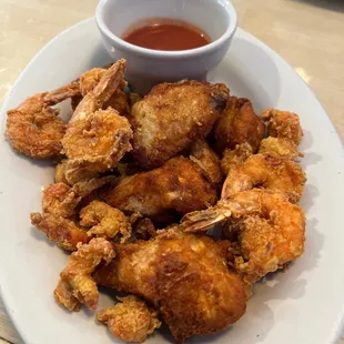 a plate of fried shrimp with dipping sauce