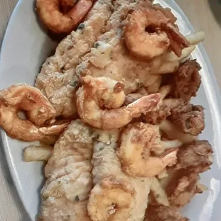 a plate of fried shrimp with a lemon wedge