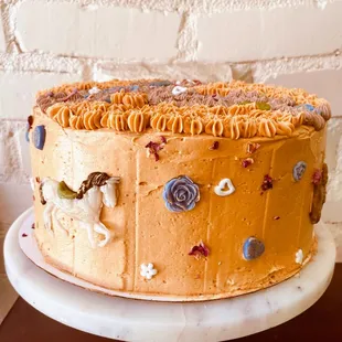 a chocolate cake with dulce de leche buttercream on the outside and chocolate on the inside, decorated with marzipan animals and roses