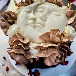 A small vegan chocolate cake with chocolate and vanilla buttercream and vanilla panna cotta