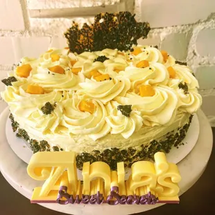 A mango cake with mango buttercream and black sesame brittle