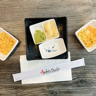 Chopsticks, small plates, ginger and wasabi, a small bite consisting of imitation crab, tempura and a little spicy mayo