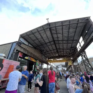 a crowd of people standing in front of a food truck