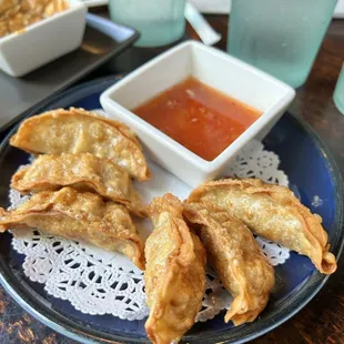 a plate of dumplings with dipping sauce