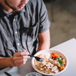 a man eating a bowl of food