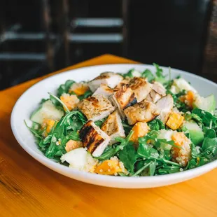 The Goods Salad featuring grilled chicken breast, over a bed of arugula, with granny smith apples. roasted sweet potatoes, and golden quinoa
