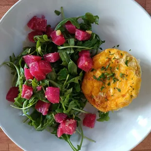 Egg and potato muffin, melted cheddar on top, serving with wild baby arugula and lightly pickled Chioggia beet.