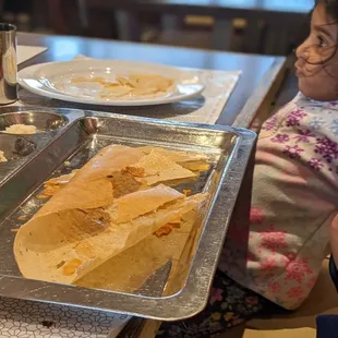 two children sitting at a table with food