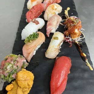 a variety of sushi on a black plate