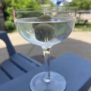 a glass of water with olives in it