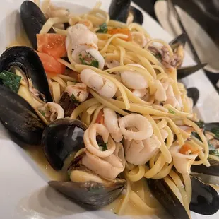 a plate of pasta with musselling and clams