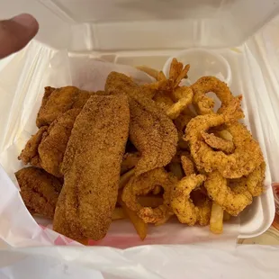 fried fish and fries in a styrofoam container