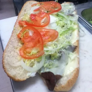 Large roast beef with cheese with everything on it