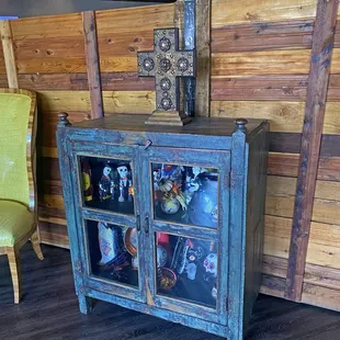 Kind of fun front entry area with some kind of 'Day of the Dead' decorations in the cabinet