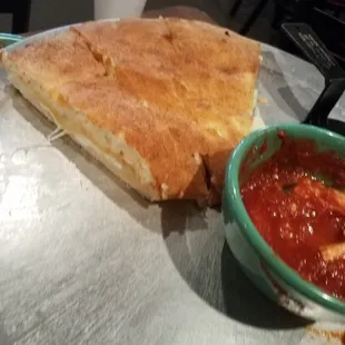 Half calzone with marinara sauce (other half eaten)