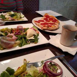 a plate of salad and a plate of pizza