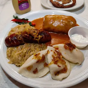 Polish platter with cheese and potato perogies, kielbasa and sauerkraut, and stuffed cabbage  Peep the potato pancakes in the back!