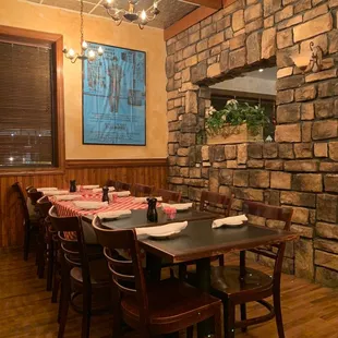 a dining room with a stone wall