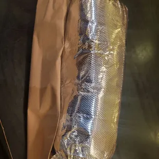 a hot dog wrapped in foil