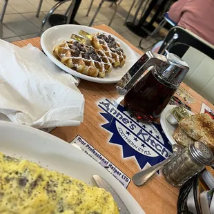 a breakfast of waffles, eggs, and coffee