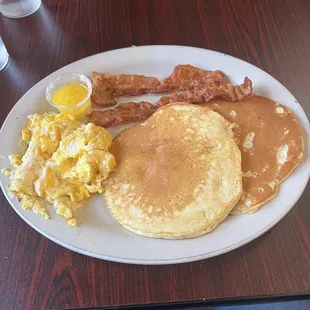 a plate of pancakes, eggs and bacon