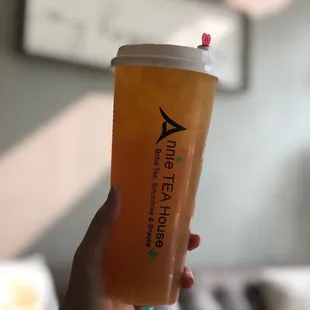 a hand holding a cup of iced tea