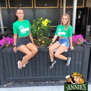 two girls sitting on a planter