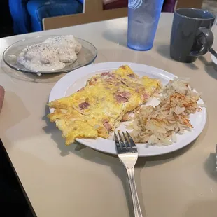 a plate of eggs, hash browns, and a fork