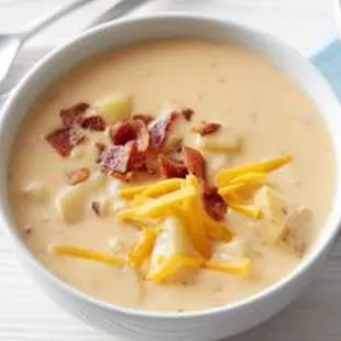 a bowl of soup with cheese and bacon