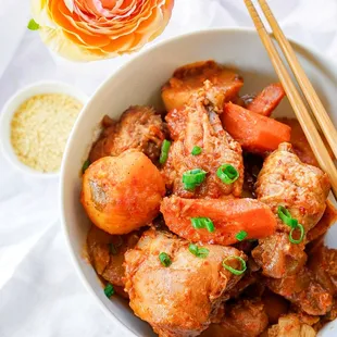 a bowl of stew and chopsticks
