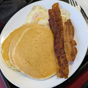 Pancake platter with over medium eggs and bacon