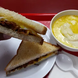 Bacon, egg, and cheese breakfast sandwich with a side of grits